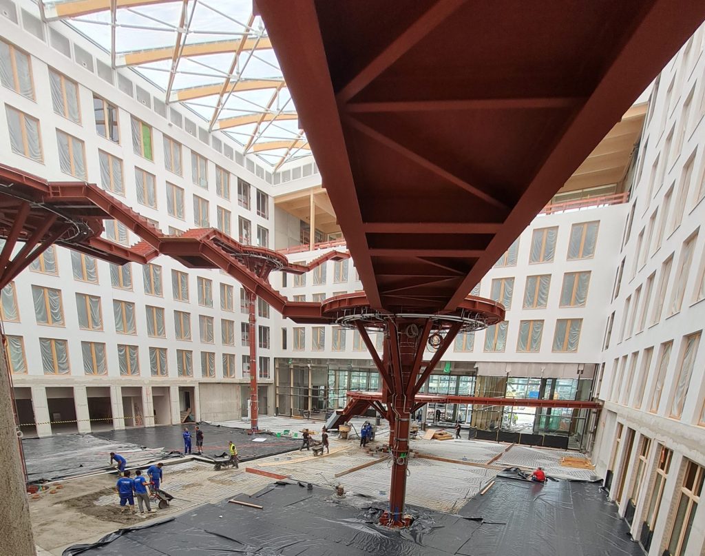 EDGE Suedkreuz Berlin: großzügiges, lichtdurchflutetes Atrium, getragen von einer Holzbinderkonstruktion